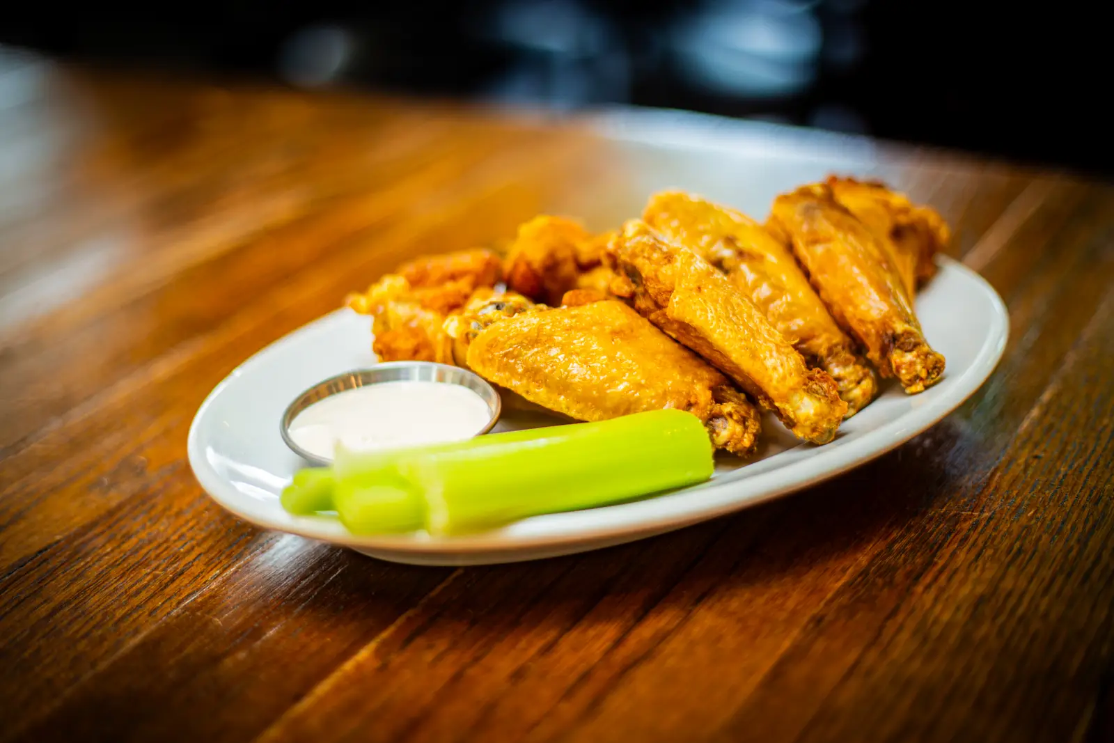 A plate of wings with celery and ranch on the Tanners bar